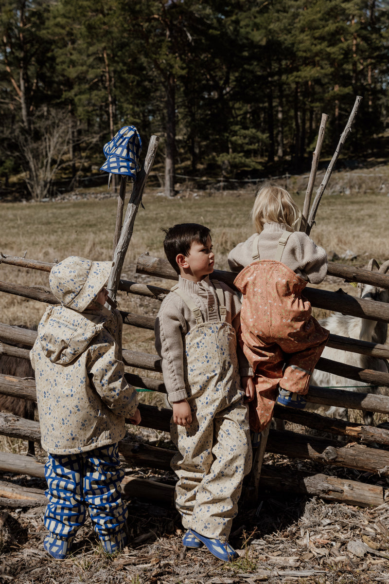 Kinder in Regenbekleidung von Garbo&Friends, Muster Oat und Checks Cobalt. 