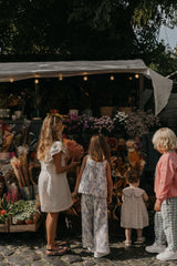 Kinder tragen diverse Kleidung und auch hier sieht man die Culottes aus weichem Baumwoll-Musselin in Beige mit gepolstertem, verstellbarem Gummizug, dekorativer Rüsche und Seitentaschen – unisex und knöchellang.