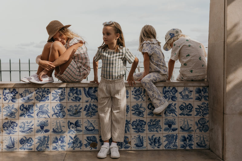 Flared Kinderleggings aus Bio-Baumwolle mit ausgestelltem Bein, handgezeichnetem Print und weichem, elastischem Bund – Mädchen trägt Leggings zur gleichen Bluse.