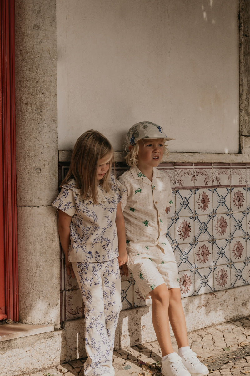 Flared Kinderleggings aus Bio-Baumwolle mit ausgestelltem Bein, handgezeichnetem Print und weichem, elastischem Bund – Mädchen trägt Leggings zur gleichen Bluse.