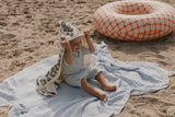 Kleinkind am Strand im UV Badeanzug, Schwimmoverall, Einteiler im Wabenmuster, vollständig gefütteres Material UV50+, Beach Outfit. Kleinkind spielt im Sand. Perfekter Einteiler für Strand.