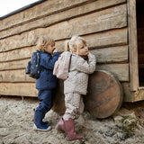 Thermo-Set aus recyceltem Polyester - Junior. Mädchen trägt Outdoor-Set drausen beim Spielen. Das Thermoset ist ideal unter Regenkleidung.