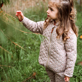 Thermo-Set aus recyceltem Polyester - Junior. Mädchen trägt Outdoor-Set drausen beim Spielen. Das Thermoset ist ideal unter Regenkleidung.