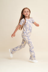 Flared Kinderleggings aus Bio-Baumwolle mit ausgestelltem Bein, handgezeichnetem Print und weichem, elastischem Bund – Mädchen trägt Leggings zur gleichen Bluse.