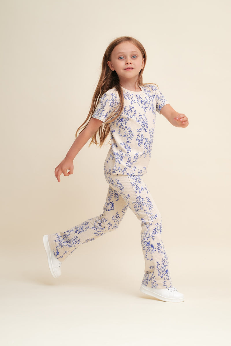 Flared Kinderleggings aus Bio-Baumwolle mit ausgestelltem Bein, handgezeichnetem Print und weichem, elastischem Bund – Mädchen trägt Leggings zur gleichen Bluse.