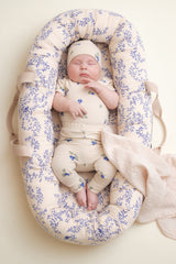 Baby trägt kurzärmeligen Body für Babys mit schönem handgezeichnetem Aufdruck aus weichem strukturiertem Bio-Baumwoll-Jersey. Der Body hat einen versteckten Druckknopf an einer Schulter und im Schritt.