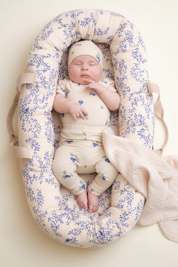Baby trägt kurzärmeligen Body für Babys mit schönem handgezeichnetem Aufdruck aus weichem strukturiertem Bio-Baumwoll-Jersey. Der Body hat einen versteckten Druckknopf an einer Schulter und im Schritt.
